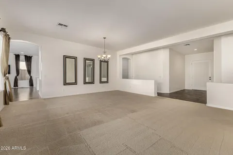 a view of a big room with windows and chandelier