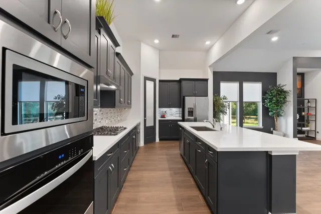 a large kitchen with stainless steel appliances a large counter top