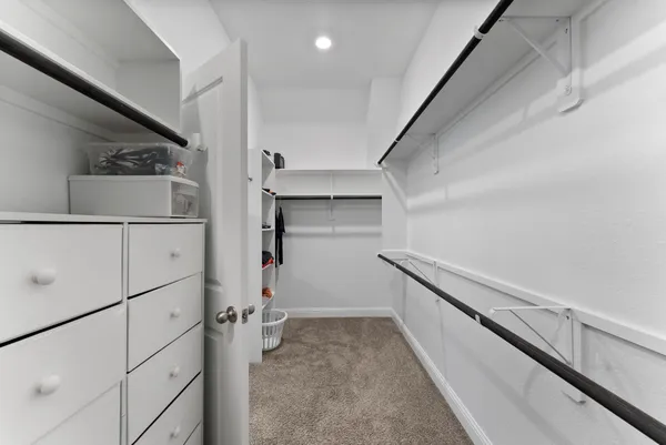 a kitchen with white cabinets and a refrigerator