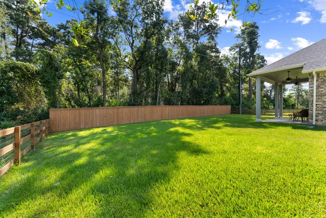 a view of yard with swimming pool and trees in the background