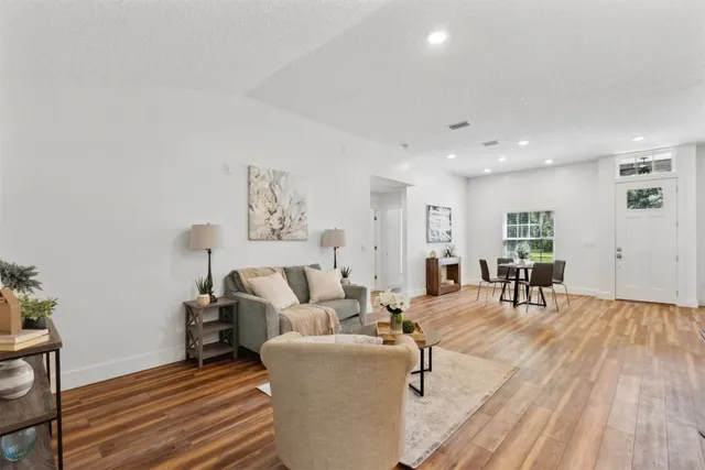 a room with kitchen island a sink and a stove with wooden floor