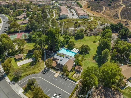 an aerial view of residential houses with outdoor space and trees