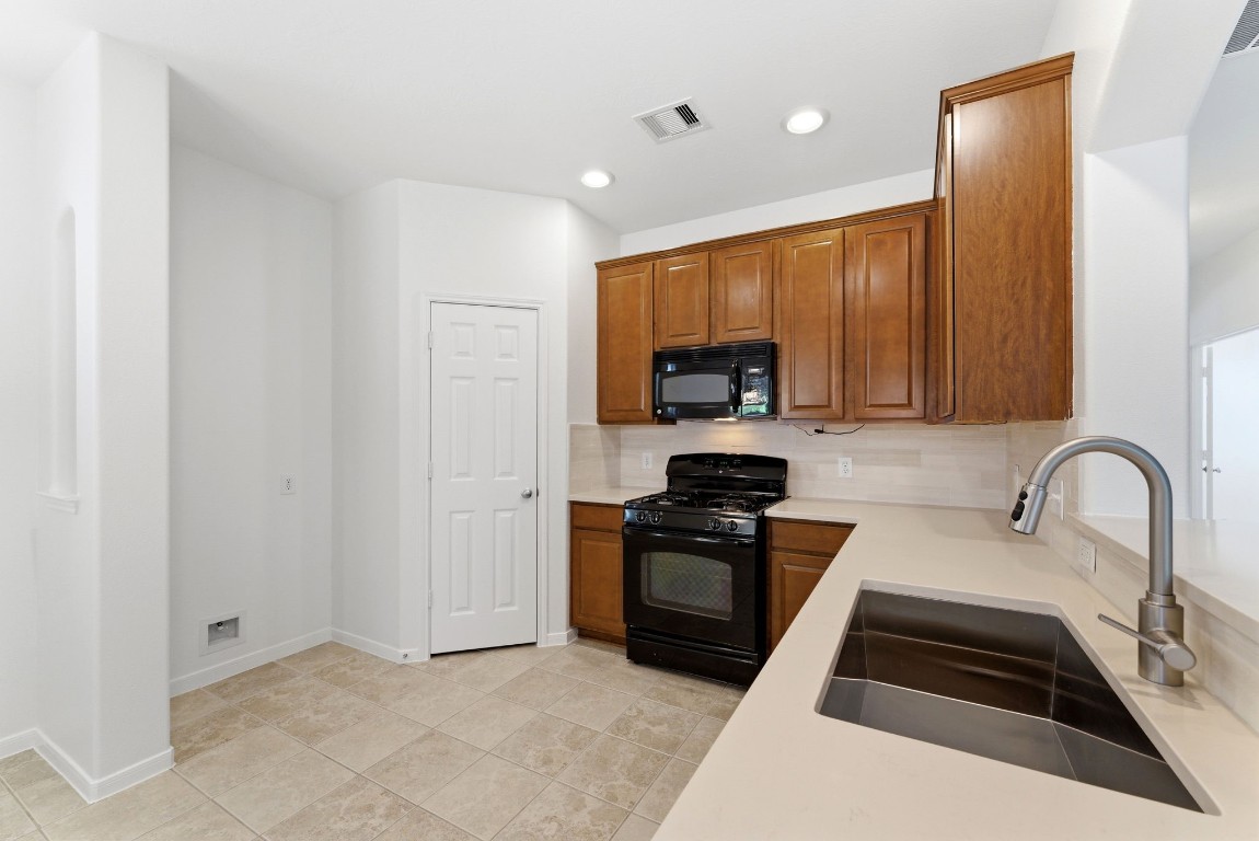 6407 Wilshire Ridge Houston, TX 77040 - Photo 17 of 37 a kitchen with granite countertop a stove a sink and a microwave