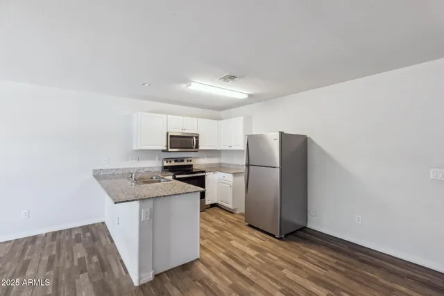 a kitchen with stainless steel appliances granite countertop a refrigerator and a stove