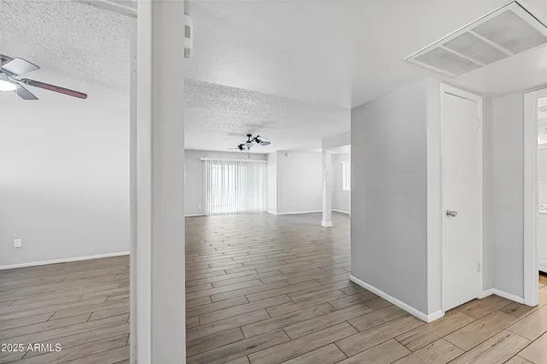 a view of a room with wooden floor and a bathroom