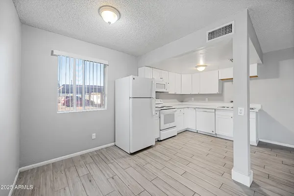 a kitchen with white cabinets and white appliances