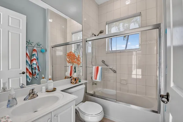 a front view of a house with a yard and palm trees