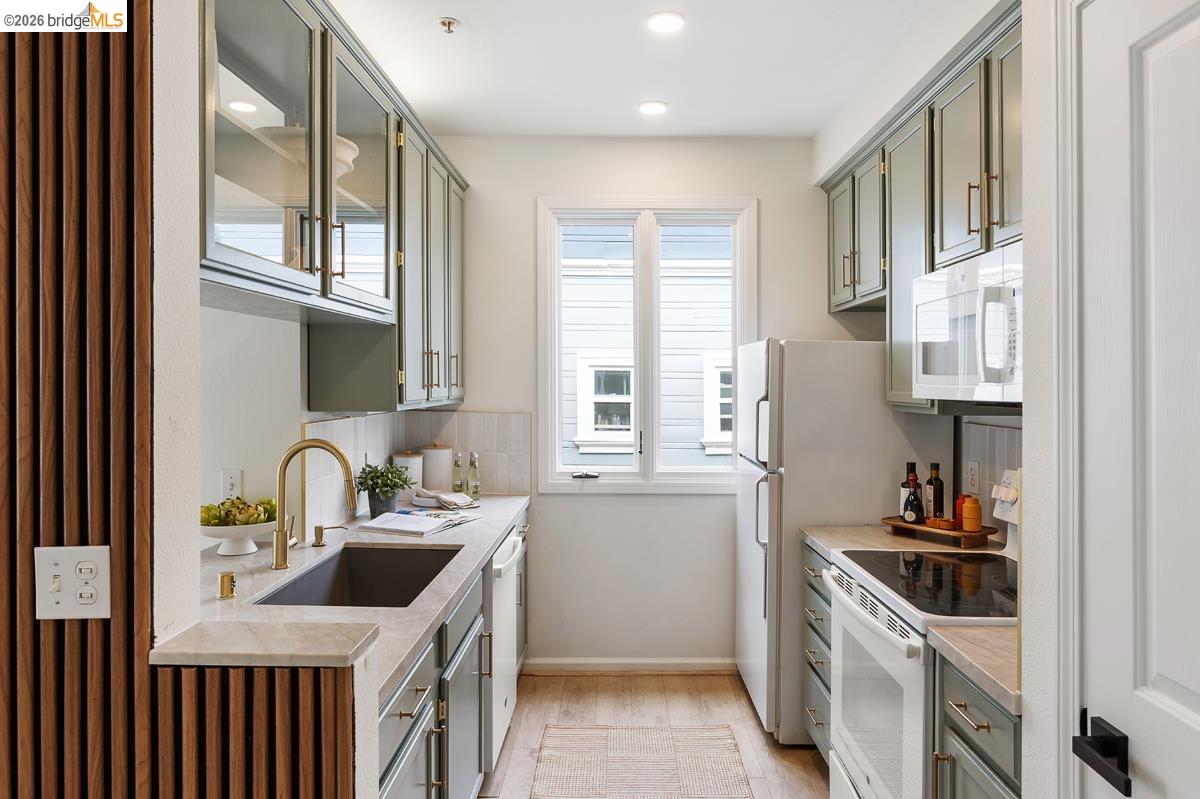 2029 Channing Way, Unit 3D Berkeley, CA 94704 - Photo 16 of 54 Galley kitchen featuring light green cabinetry, a single window, recessed lighting, and wood-finish flooring