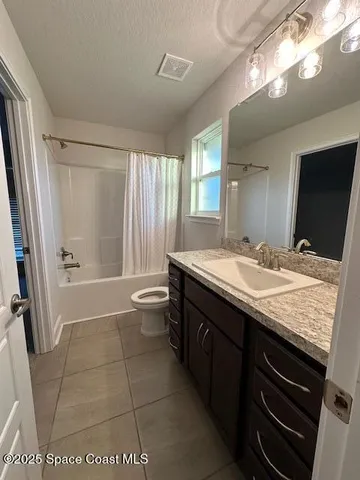 a bathroom with a granite countertop sink a toilet a mirror and shower