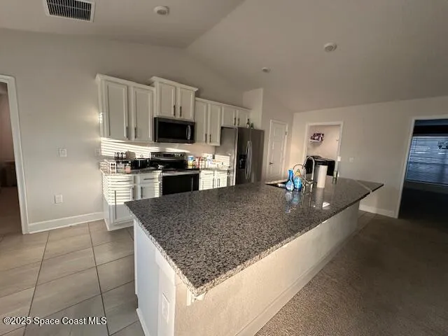 a kitchen with stainless steel appliances granite countertop a stove a refrigerator and a microwave