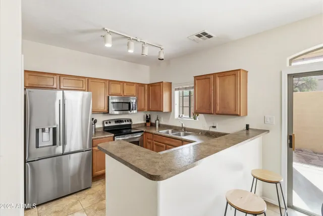 a kitchen with stainless steel appliances granite countertop a sink stove and refrigerator