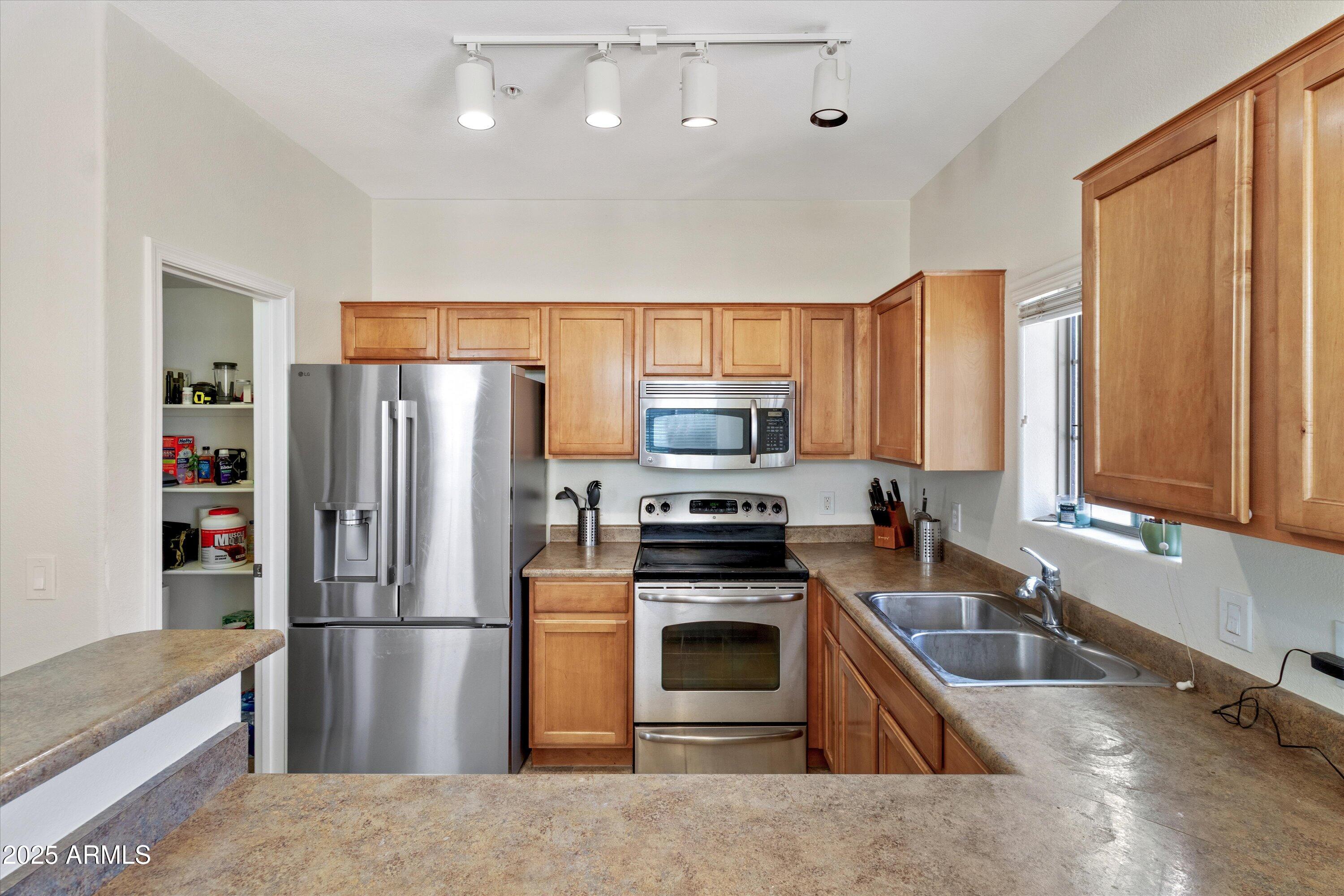 2727 North Price Road, Unit 50 Chandler, AZ 85224 - Photo 10 of 32 a kitchen with stainless steel appliances granite countertop a refrigerator stove and sink