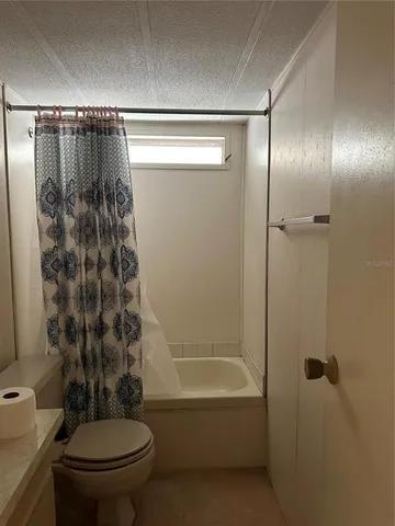 a spacious bathroom with a granite countertop sink a toilet and shower