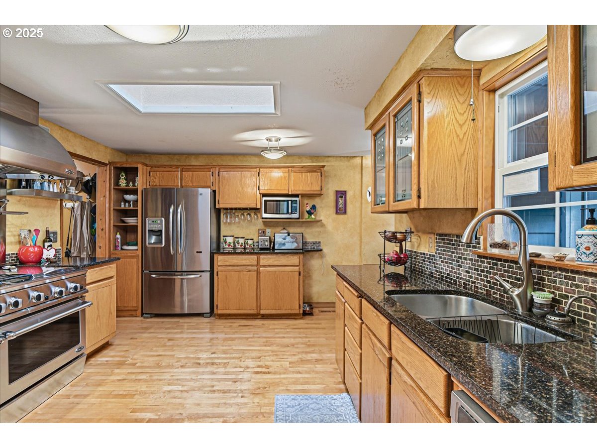 1820 Southwest Heiney Road Gresham, OR 97080 - Photo 12 of 48 a kitchen that has a sink cabinets counter space stainless steel appliances and a window
