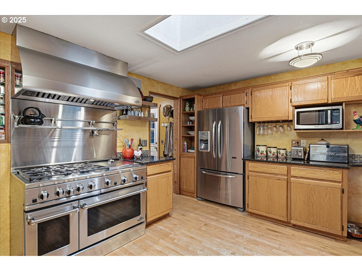 1820 Southwest Heiney Road Gresham, OR 97080 - Photo 15 of 48 a kitchen with stainless steel appliances granite countertop a stove and a refrigerator
