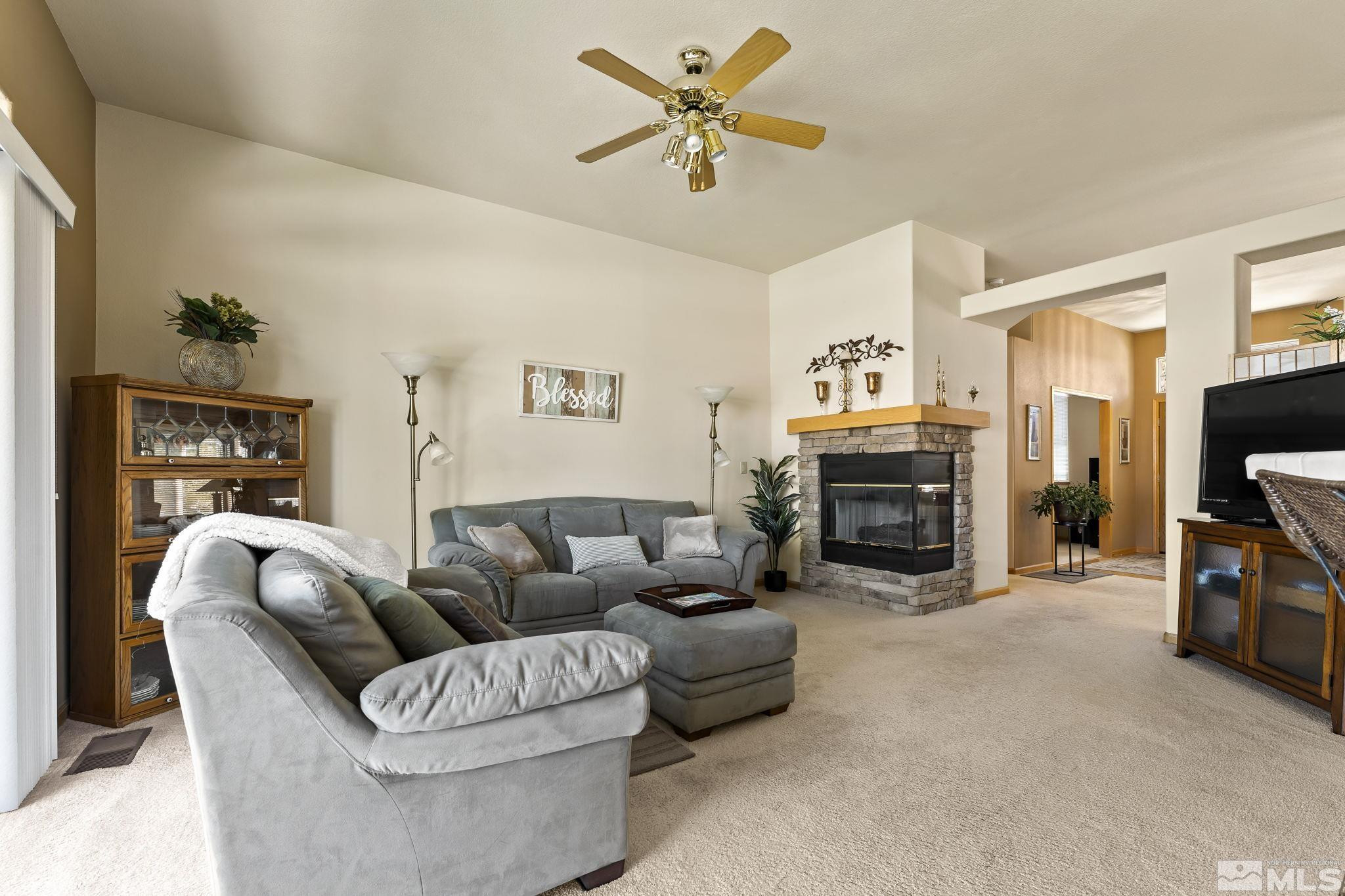 1021 University Place Reno, NV 89512 - Photo 12 of 40 a living room with furniture a fireplace and a flat screen tv