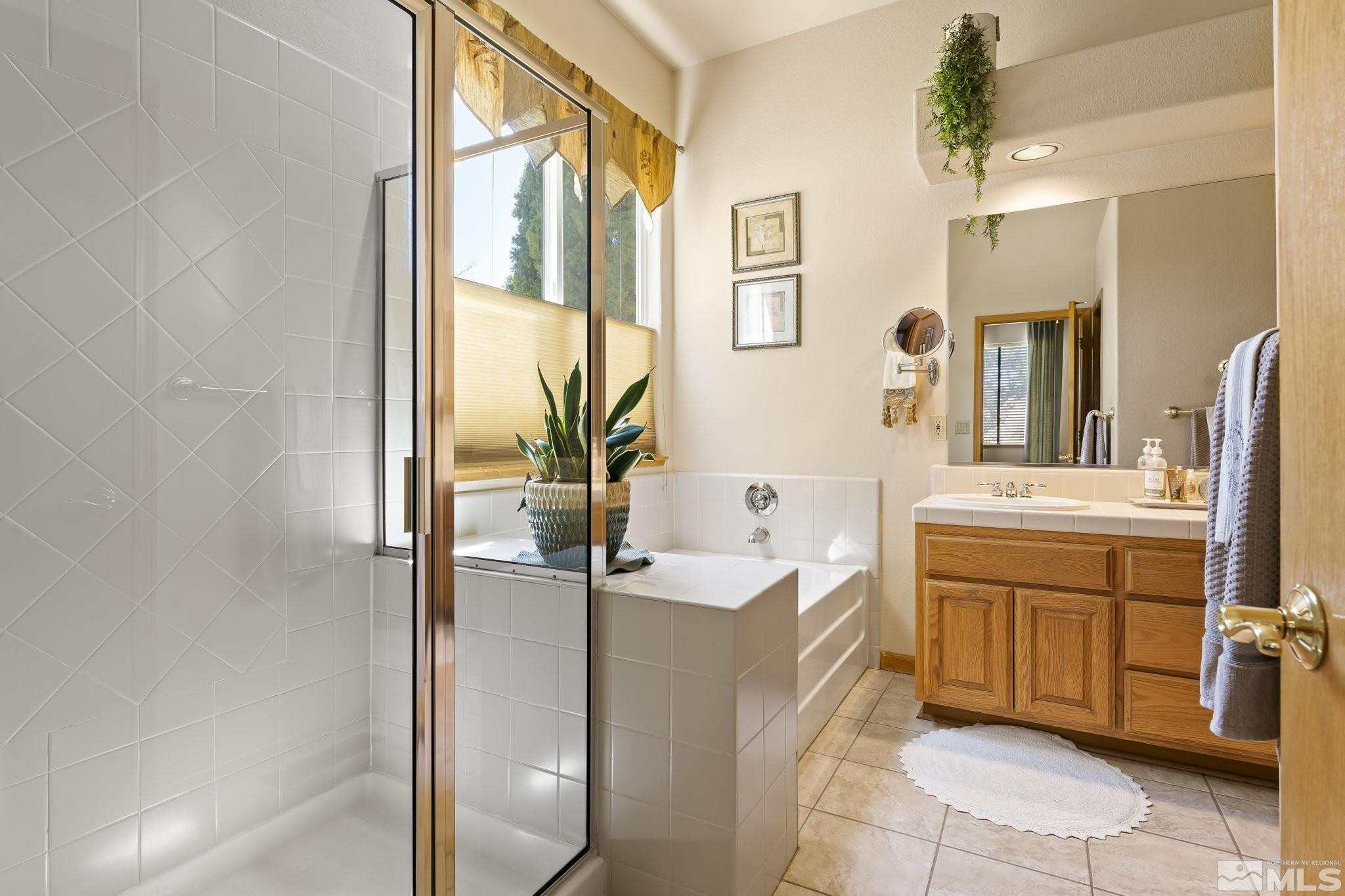 1021 University Place Reno, NV 89512 - Photo 20 of 40 a bathroom with a tub sink and mirror