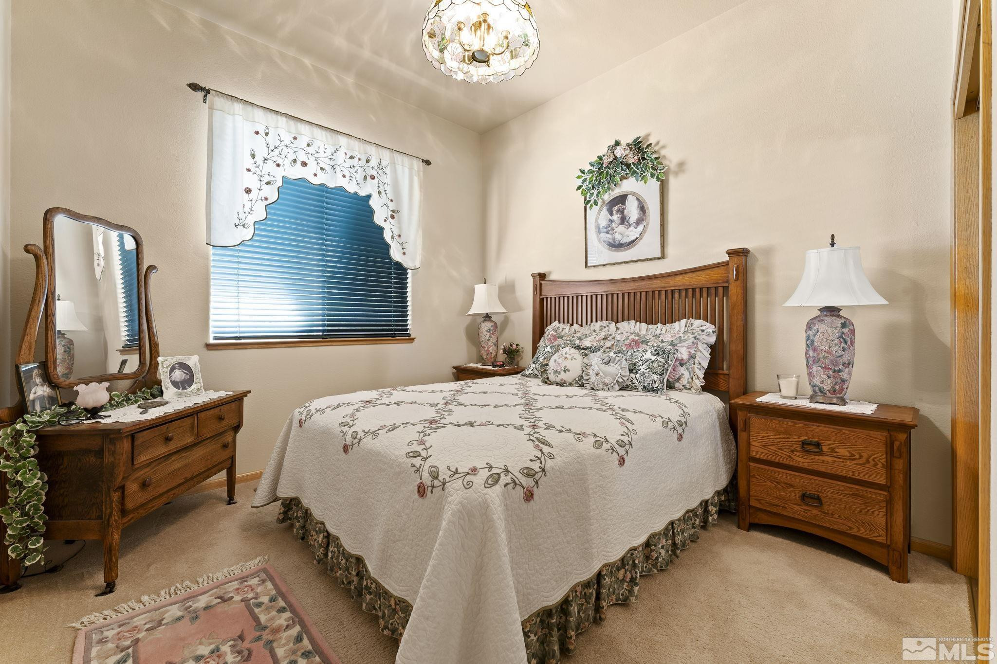 1021 University Place Reno, NV 89512 - Photo 24 of 40 a spacious bedroom with a bed and a mirror on the dresser