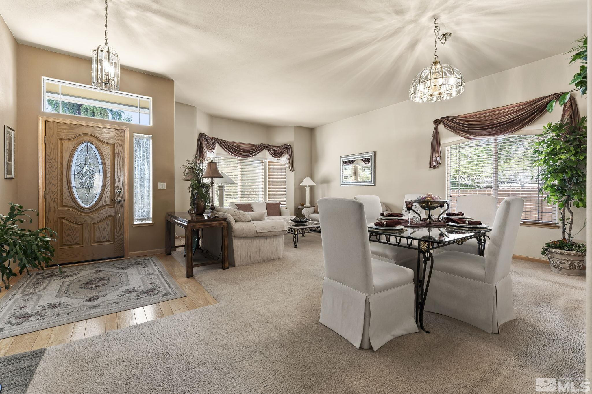 1021 University Place Reno, NV 89512 - Photo 3 of 40 a living room with furniture a chandelier a rug a fireplace and a chandelier
