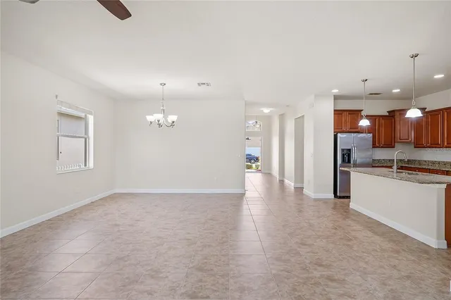 an empty room with kitchen view and stainless steel appliances
