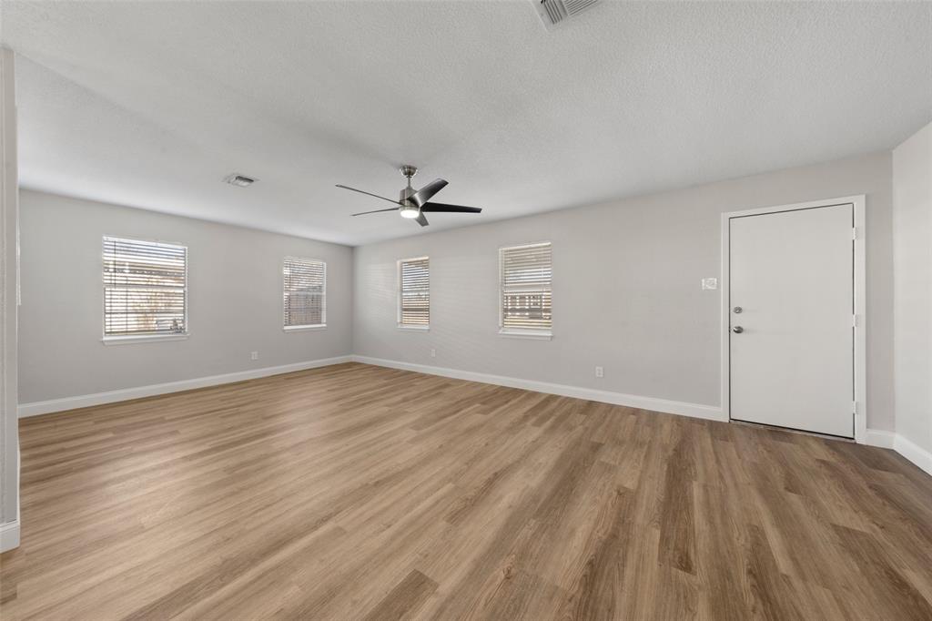 1312 Crow Drive Waco, TX 76705 - Photo 7 of 22 an empty room with wooden floor chandelier fan and windows