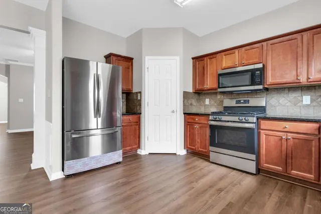 a kitchen with wooden floors and stainless steel appliances