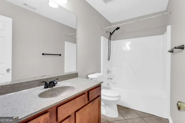a bathroom with a granite countertop sink toilet a mirror and shower