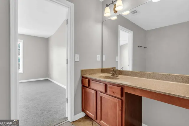 a bathroom with a granite countertop sink and a mirror