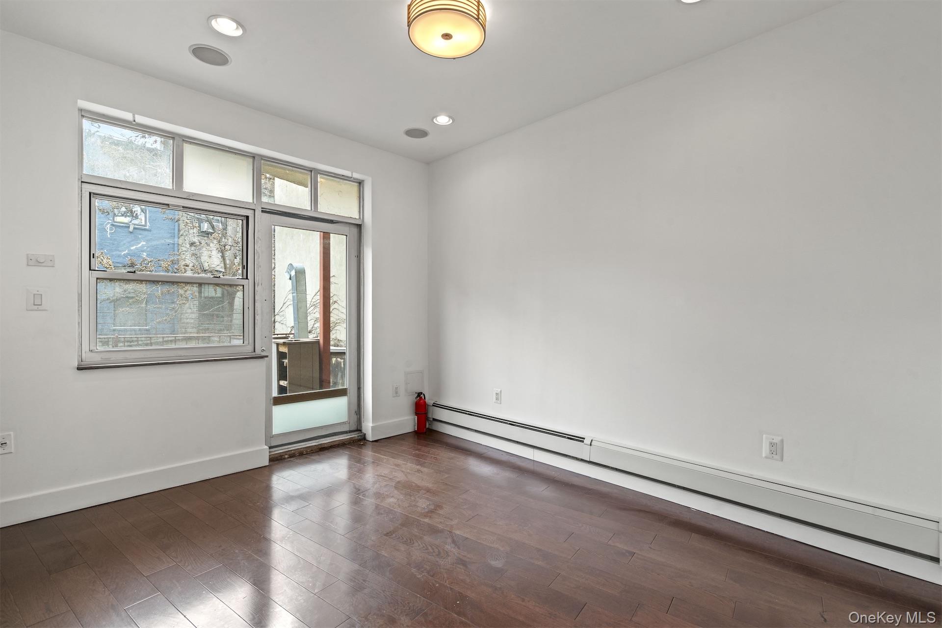 44-46 Decatur Street Brooklyn, NY 11216 - Photo 39 of 50 Unfurnished room featuring a baseboard radiator, dark wood-style floors, and recessed lighting