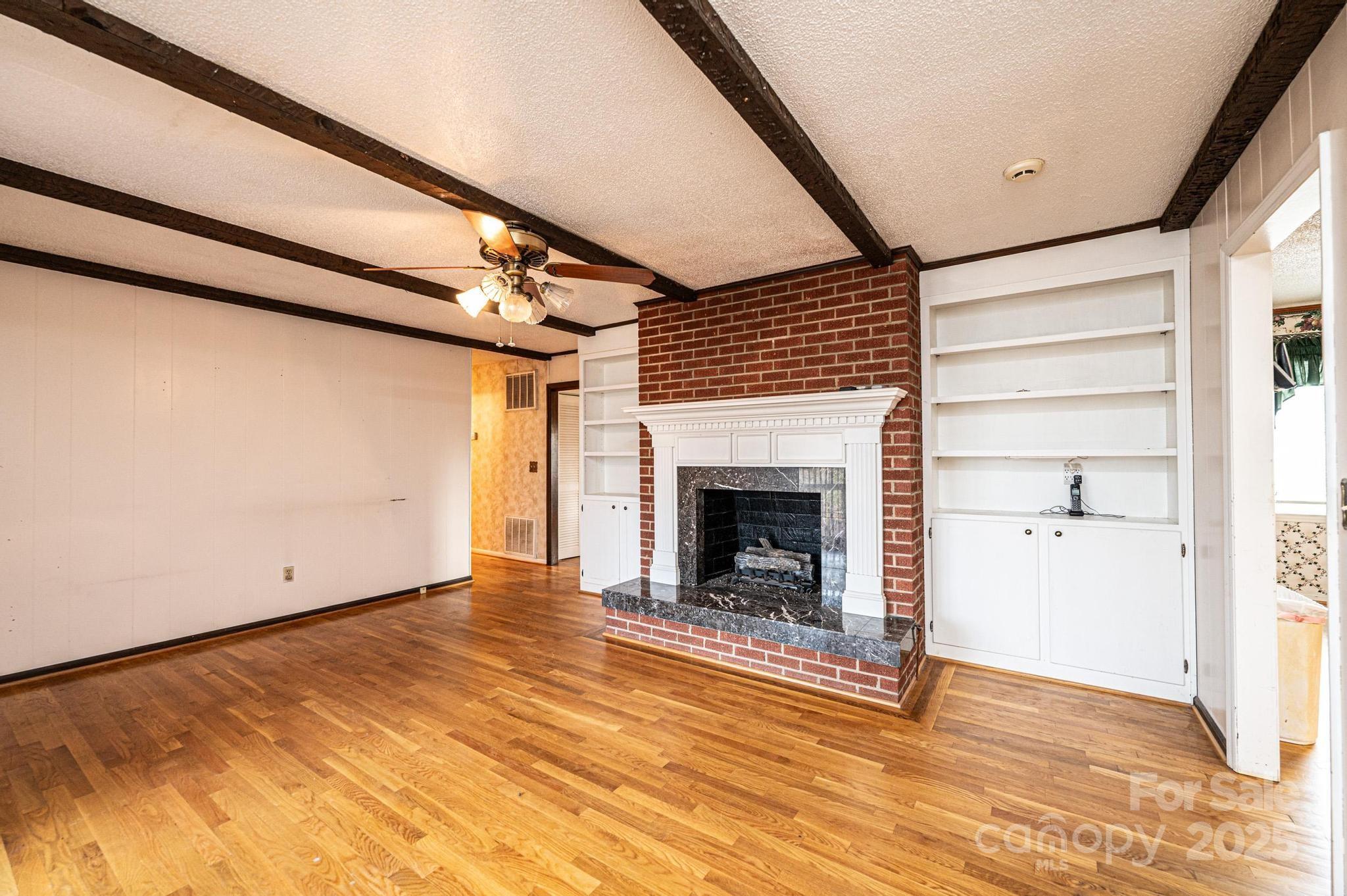 6000 George Hildebran School Road Hickory, NC 28602 - Photo 6 of 21 a view of empty room with wooden floor and fireplace