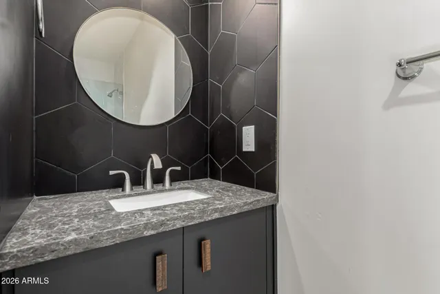 a bathroom with a granite countertop sink and a mirror