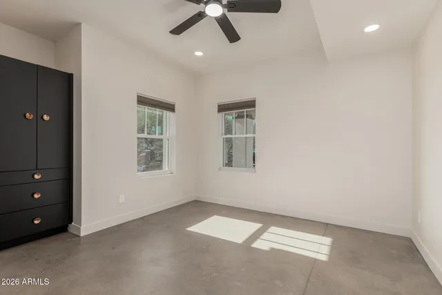 an empty room with a ceiling fan and window