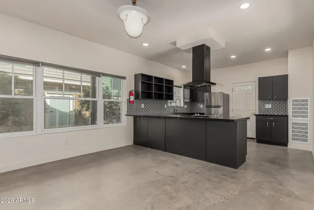 a kitchen with stainless steel appliances kitchen island granite countertop a stove and a sink
