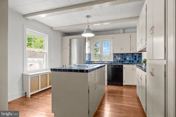 a kitchen with refrigerator a stove a sink and a window