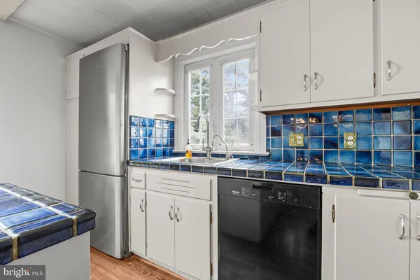 a kitchen with stainless steel appliances granite countertop a sink and a refrigerator