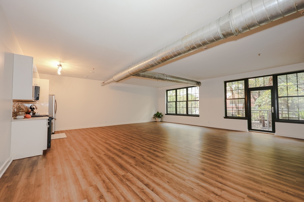 944 Dorchester Avenue, Unit 9 Boston, MA 02125 - Photo 15 of 29 a view of an empty room with wooden floor and a window