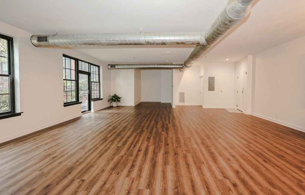 944 Dorchester Avenue, Unit 9 Boston, MA 02125 - Photo 19 of 29 a view of a room with wooden floor and windows