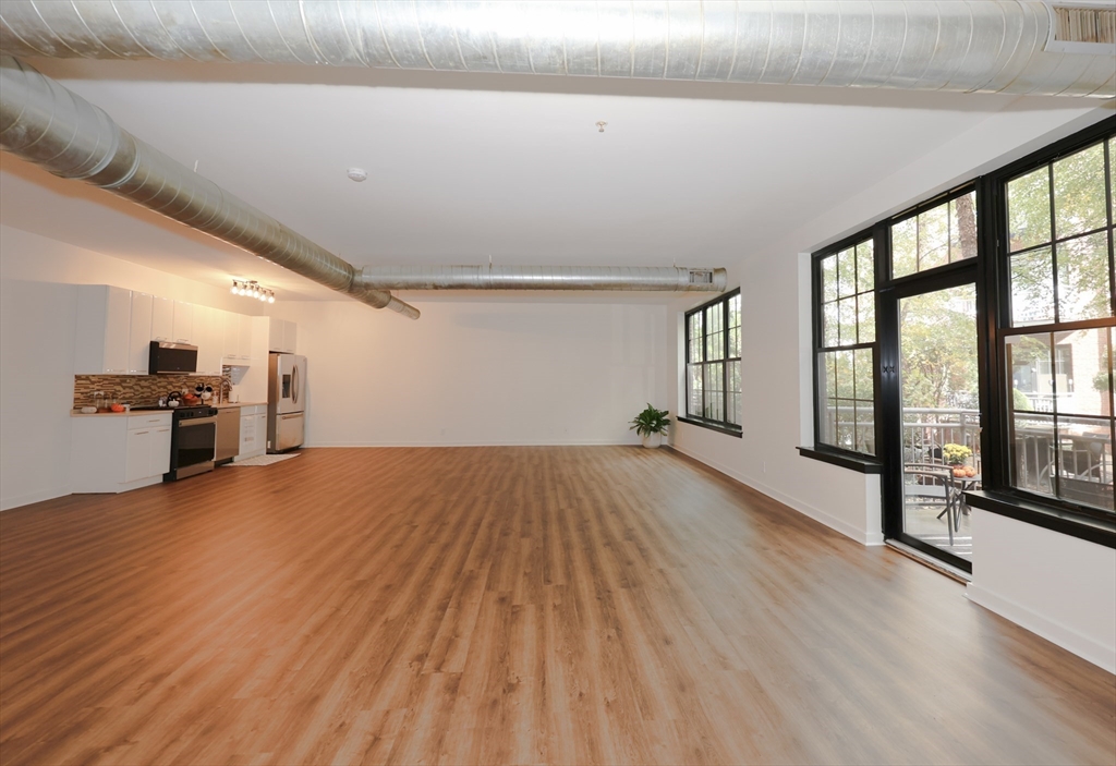 944 Dorchester Avenue, Unit 9 Boston, MA 02125 - Photo 10 of 29 a view of empty room with wooden floor and windows