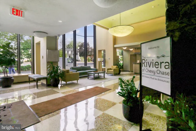 a building with potted plants and a large tree