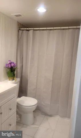 a bathroom with a shower curtain and a toilet