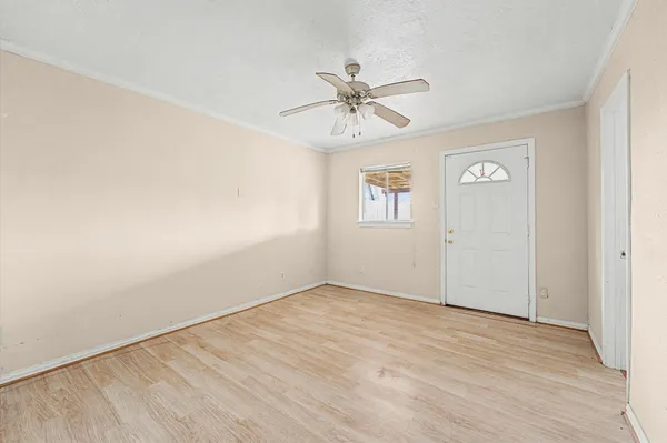 an empty room with windows and fan