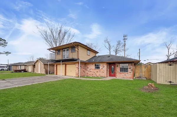 a view of a house with a big yard and large trees