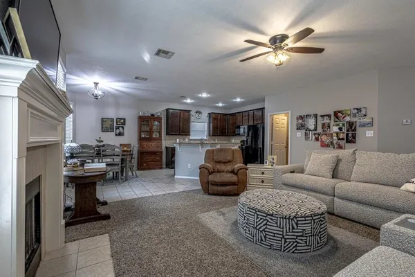 a living room with furniture a chandelier and a rug