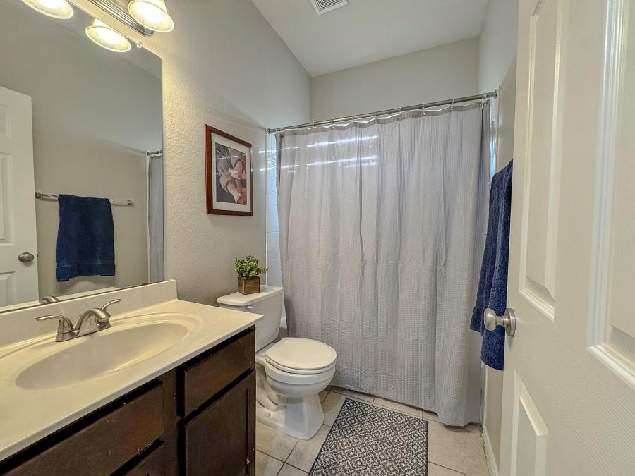 10165 China Creek Drive Waco, TX 76708 - Photo 8 of 36 a bathroom with a granite countertop sink toilet a mirror a vanity and shower