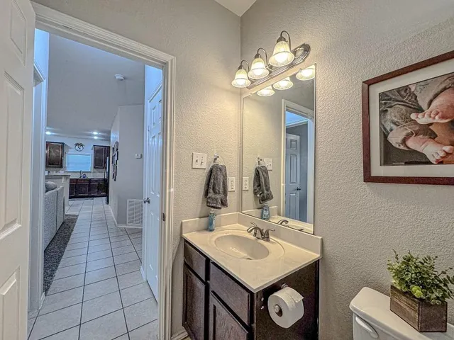 a bathroom with a granite countertop sink toilet a mirror a vanity and shower