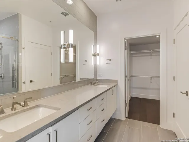 a spacious bathroom with a granite countertop sink and a mirror