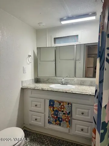 a bathroom with a granite countertop sink and a mirror