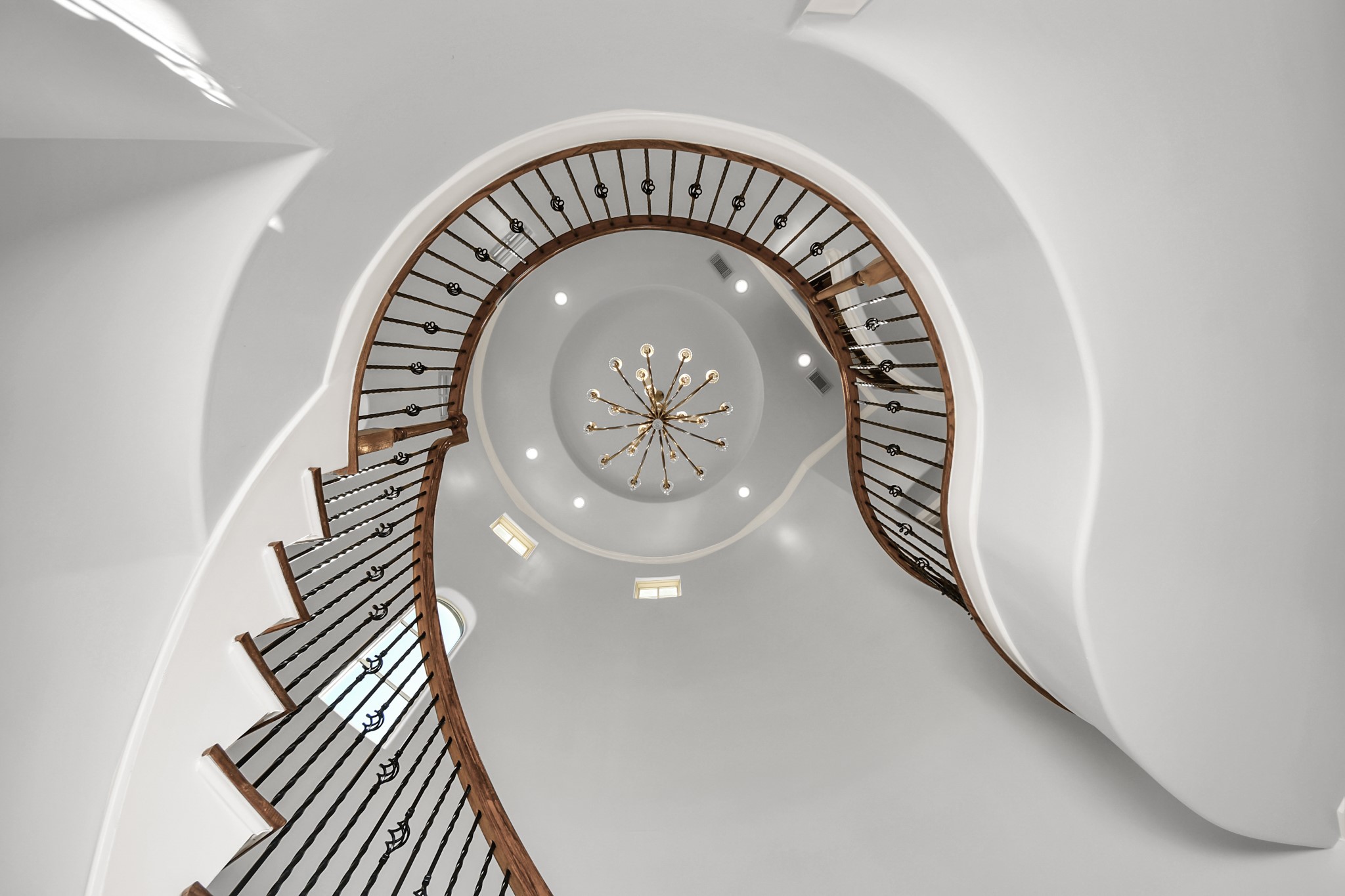 6302 Hermann Lake Drive Houston, TX 77021 - Photo 8 of 50 Looking up, the dramatic architecture of the home truly comes to life. Natural light filters through the upper windows, highlighting the elegant lines and craftsmanship throughout the space.
