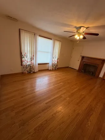 a view of a room with wooden floor and window