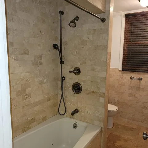 a bathroom with a bath tub with a shower